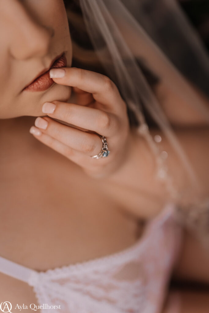 Bride detail shot during boudoir shoot showing wedding ring